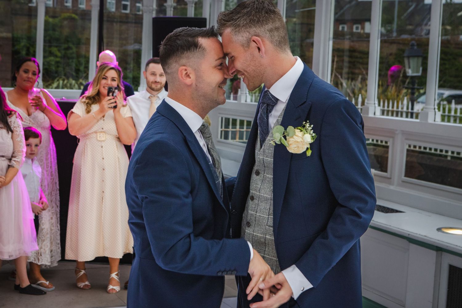 Wedding celebration under ornate glass conservatory roof.