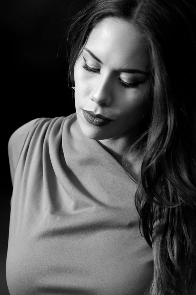 A black and white photograph of a beautiful woman wearing a vintage red dress.