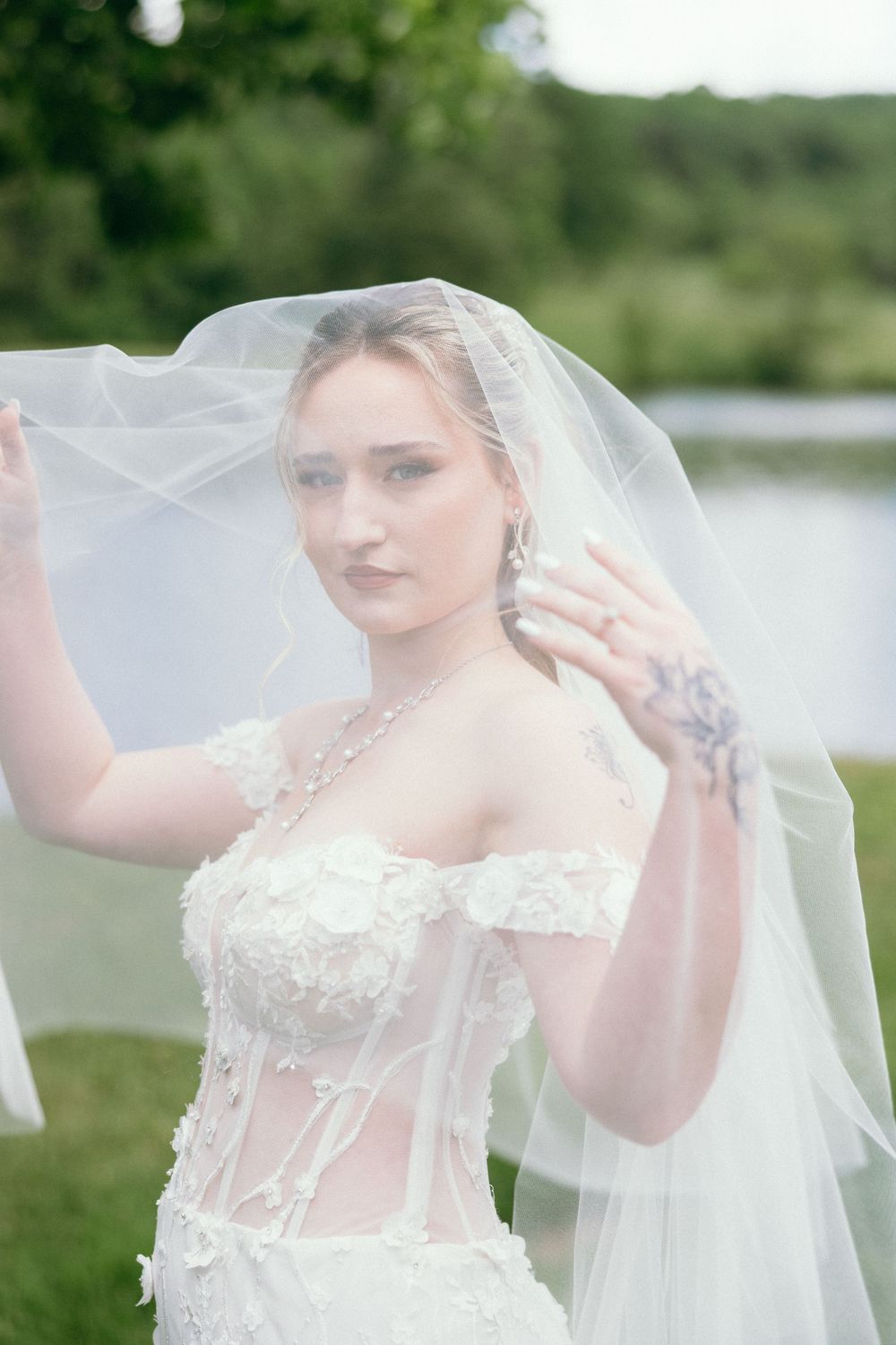 A delicate bridal veil flows in the breeze against a natural outdoor backdrop. Estate and historic venue wedding photographer