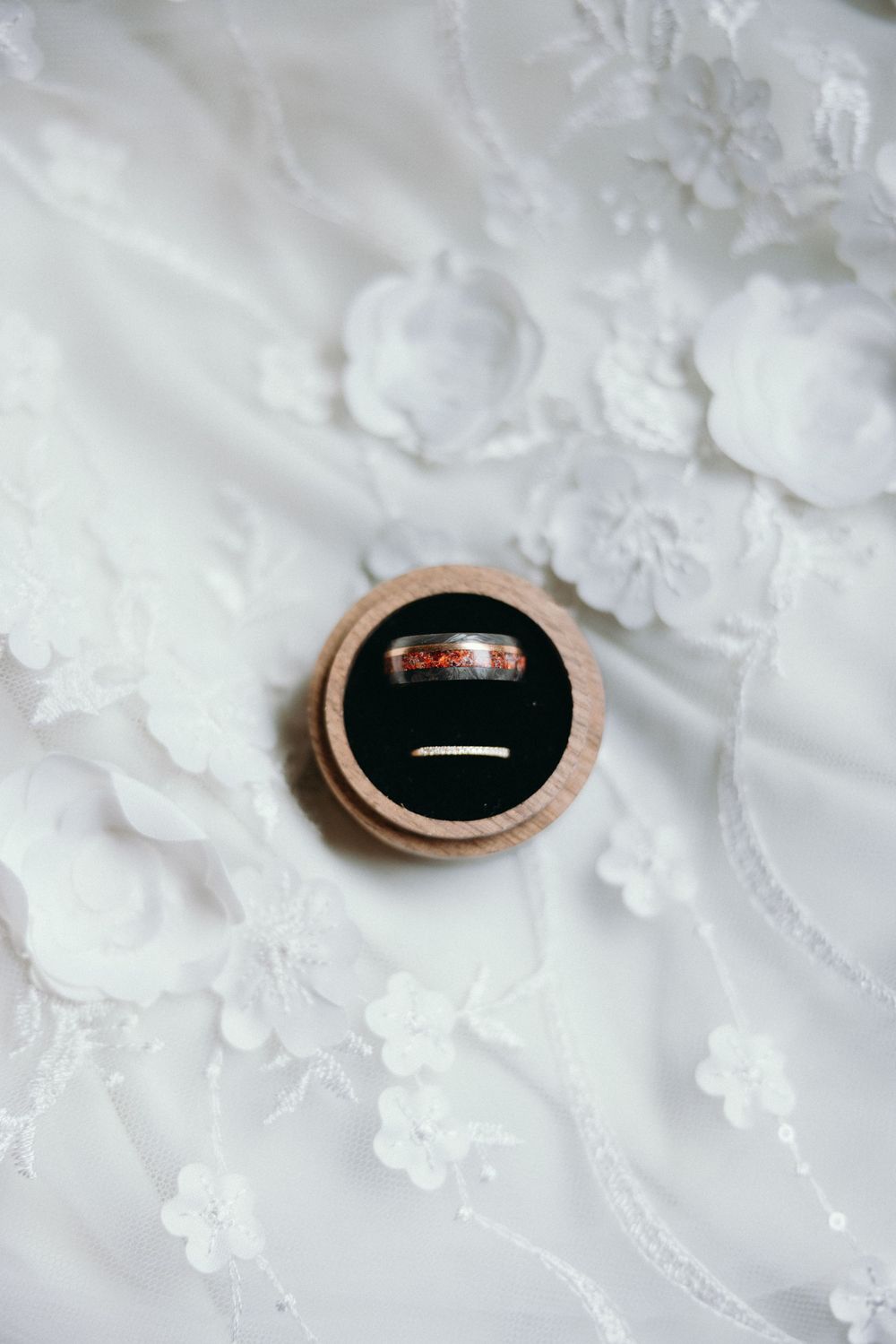 Wedding ring displayed in a wooden ring box on white lace fabric. Estate and historic venue wedding photographer for NC