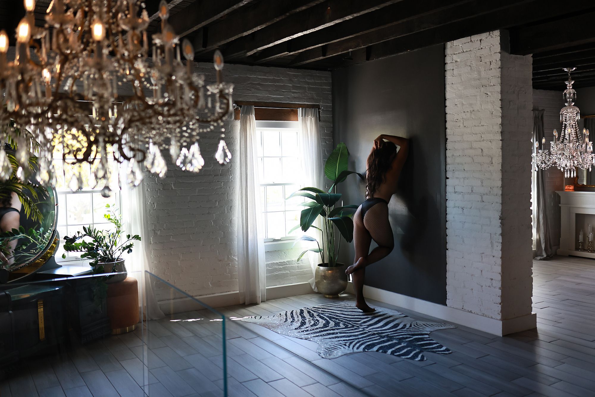Elegant room with crystal chandeliers and brick walls.