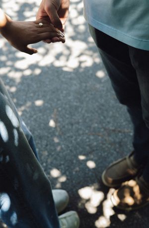 Close-up view of feet and legs on a sunlit pathway with dappled shadows creating a romantic atmosphere.