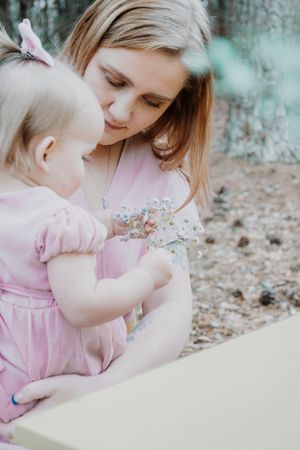 A tender moment between parent and child looking at flowers in a garden setting.