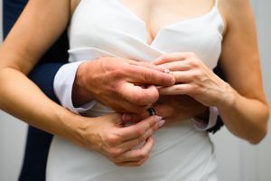 Close-up shot of hands exchanging wedding rings during a marriage ceremony.