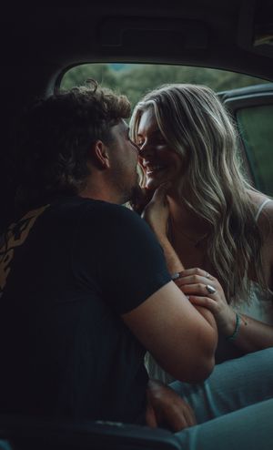 A romantic sequence of silhouetted figures sharing intimate kisses in a dimly lit setting.