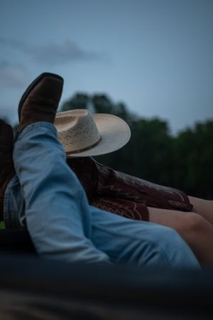 A cowboy hat silhouetted against a dusky blue sky in a sequence of moody, atmospheric shots.