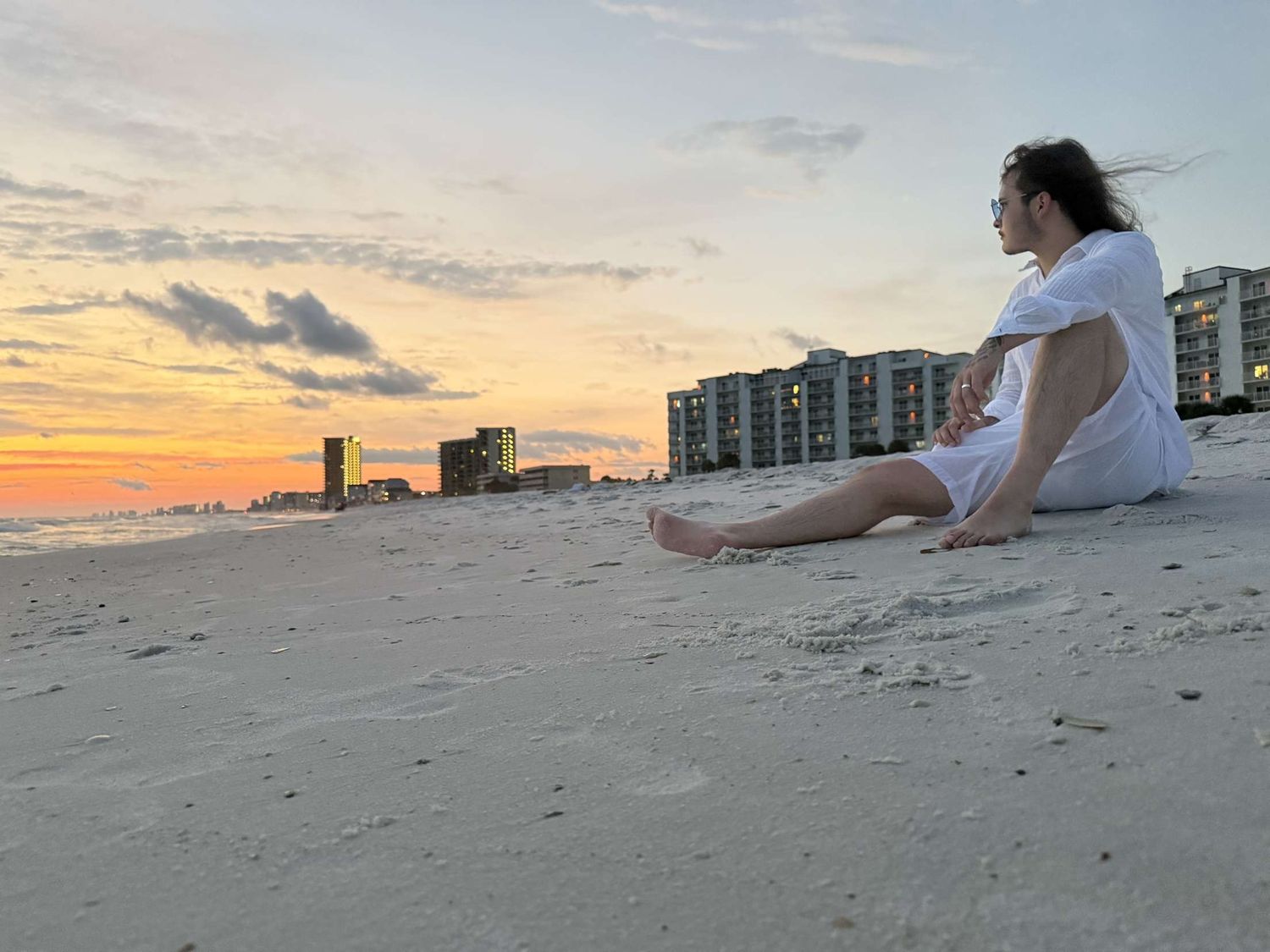 Alex on the beach with a sunset in the background.
