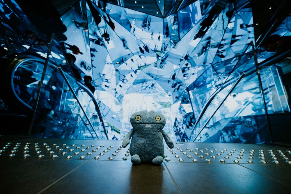 Abstract blue shattered glass patterns create a dynamic crystalline backdrop in dramatic lighting.