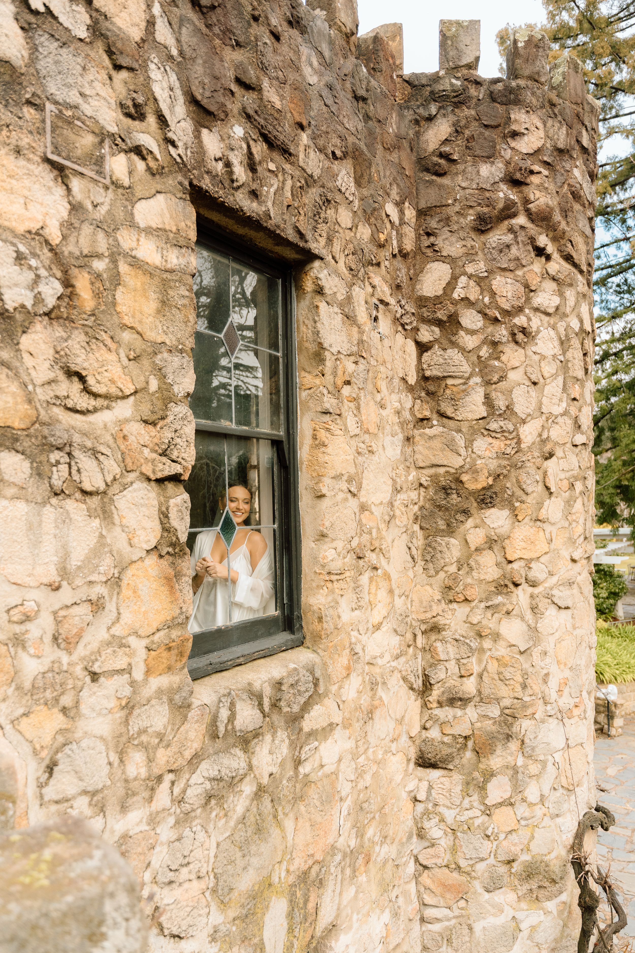 Stone wall exterior with vintage windows in natural lighting.
