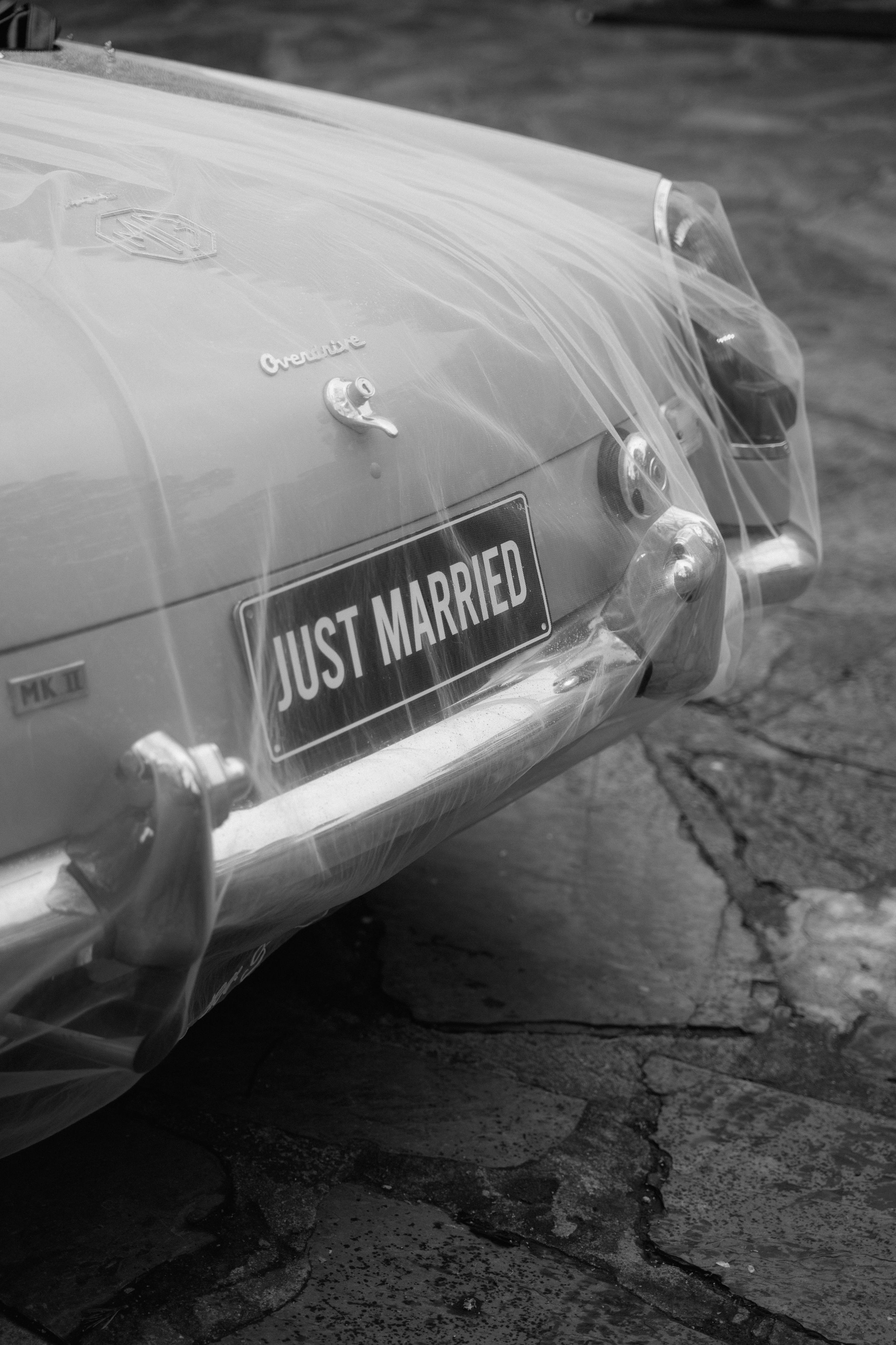 Classic vintage car with Just Married sign in black and white photography.