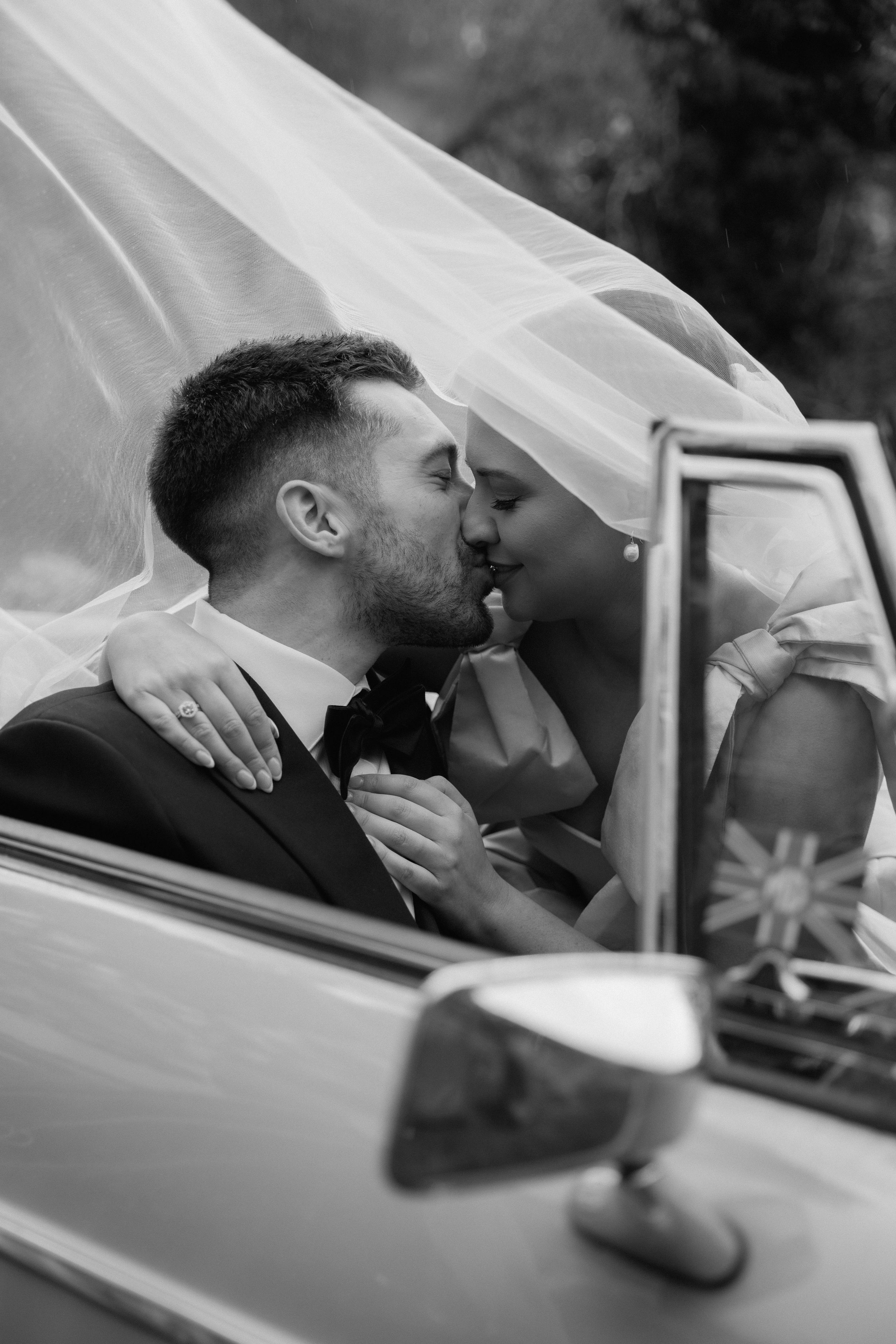 A series of intimate black and white photos showing a couple kissing in a car.