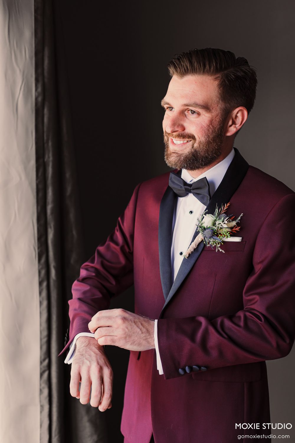 Candid moment captured in natural light showing formal burgundy attire.