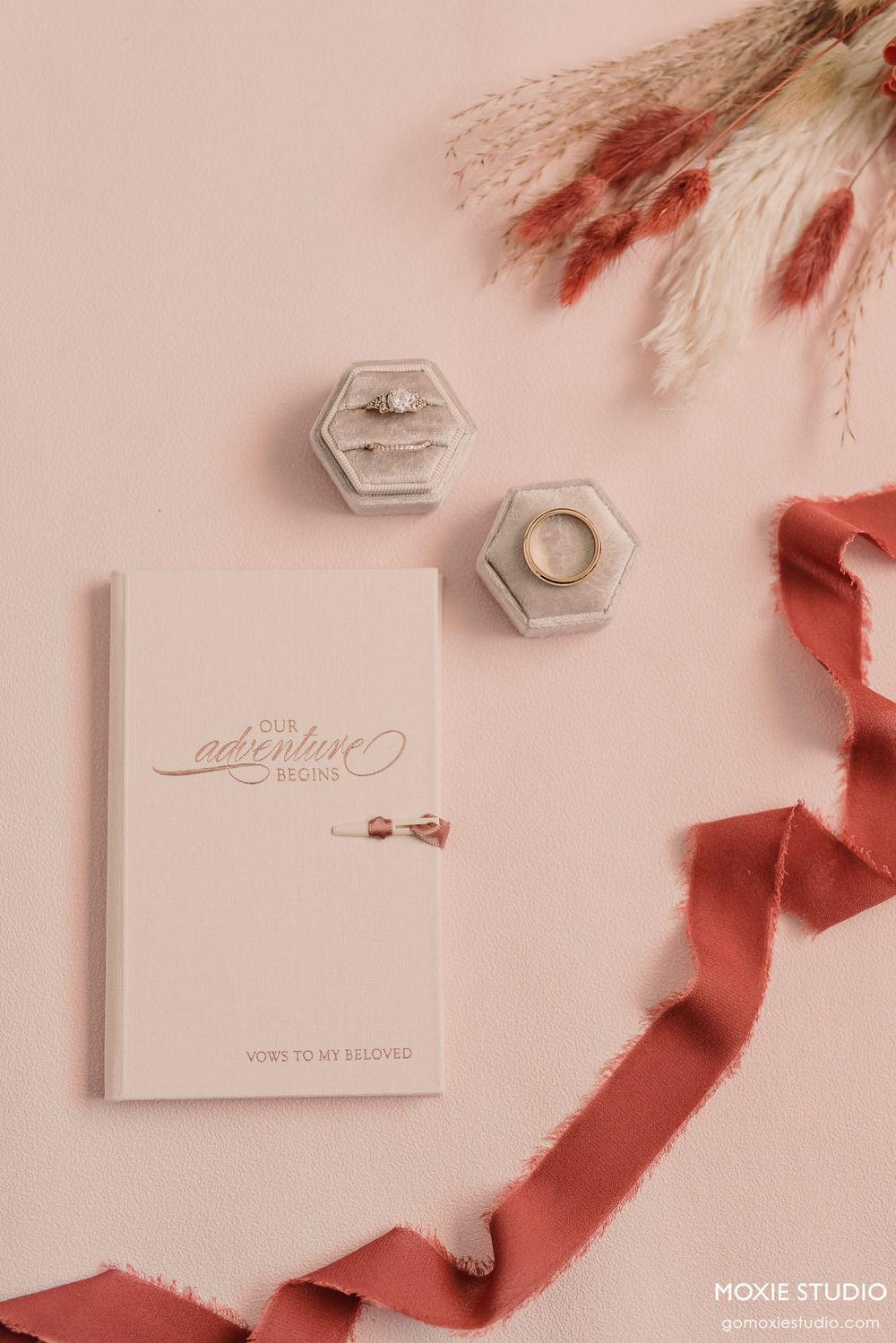 Wedding stationery with hexagonal details and calligraphy on pink background with silk ribbons.