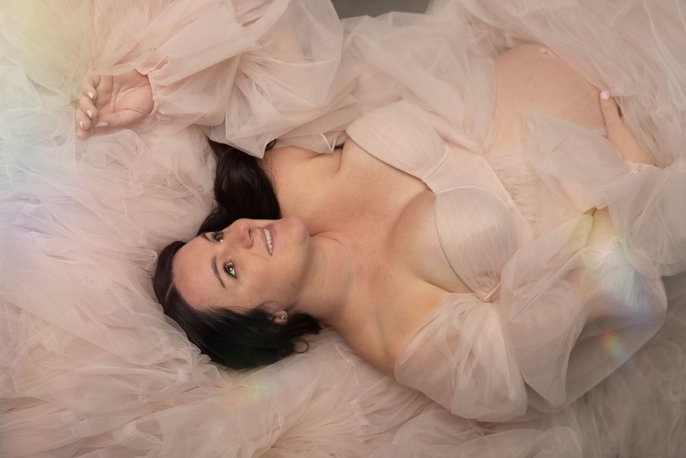 Ethereal boudoir photography series featuring dreamy peach tulle fabric and soft romantic lighting.