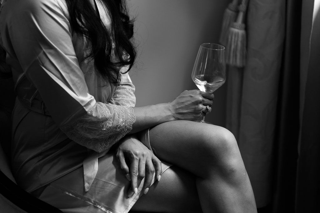 A sequence of black and white intimate portraits showing a person holding a wine glass in different poses.