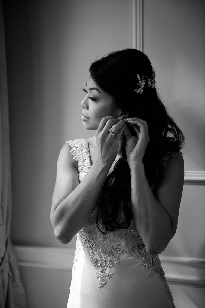 A sequence of black and white photos shows a bride putting on earrings while getting ready for her wedding day.