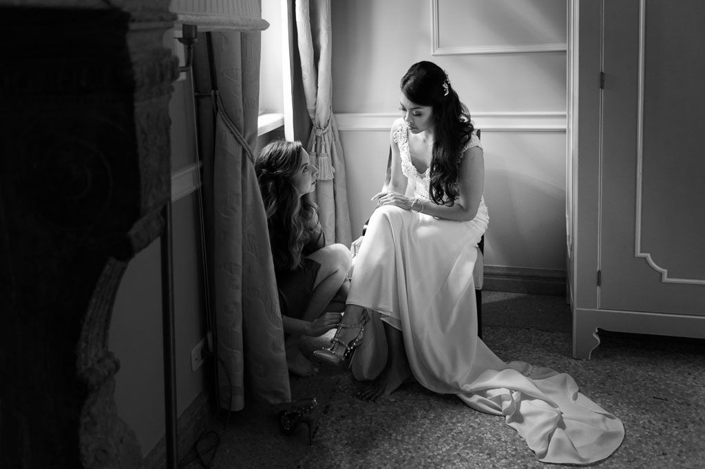 Artistic black and white photos capture a bride's preparation moments in natural window light.