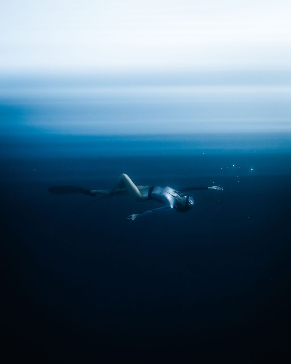 A sequence of aerial shots showing humpback whales breaching and diving in dark blue ocean waters.