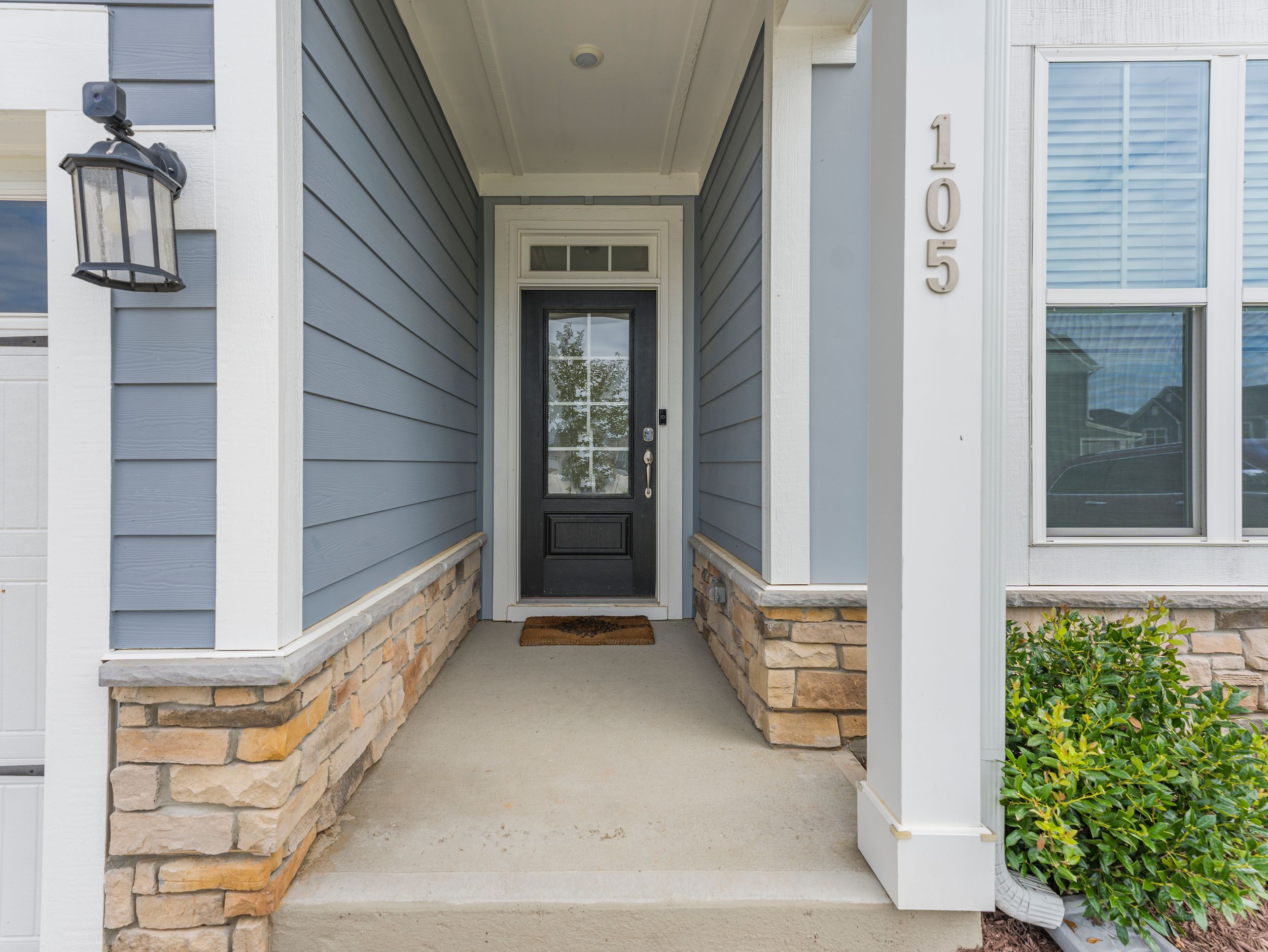 Row of modern townhomes with stone accents and covered entryways.