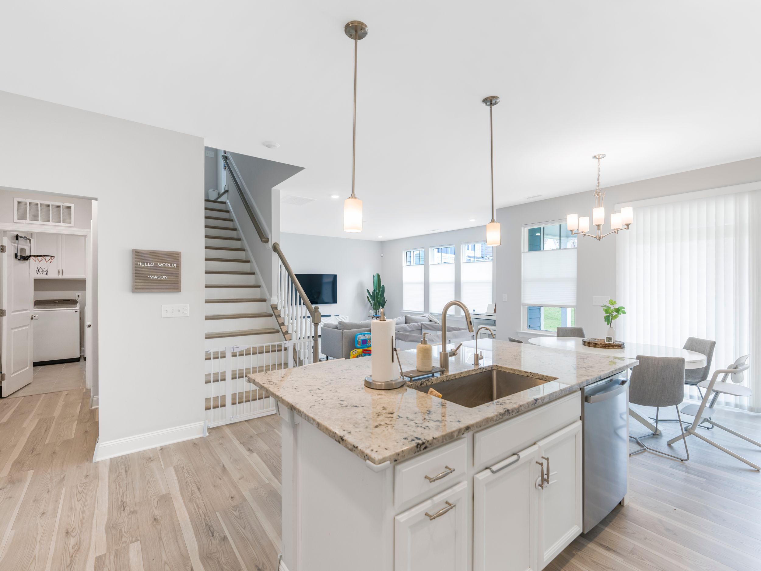 Bright contemporary kitchen featuring white cabinets, granite counters and stainless steel appliances.