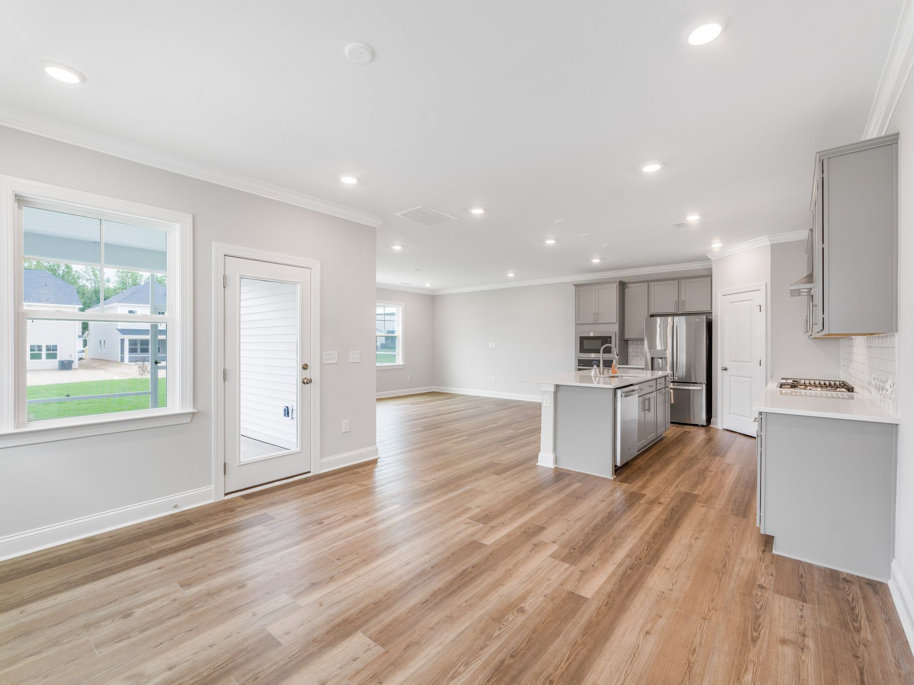 Spacious open floor plan interior with hardwood floors and recessed lighting.