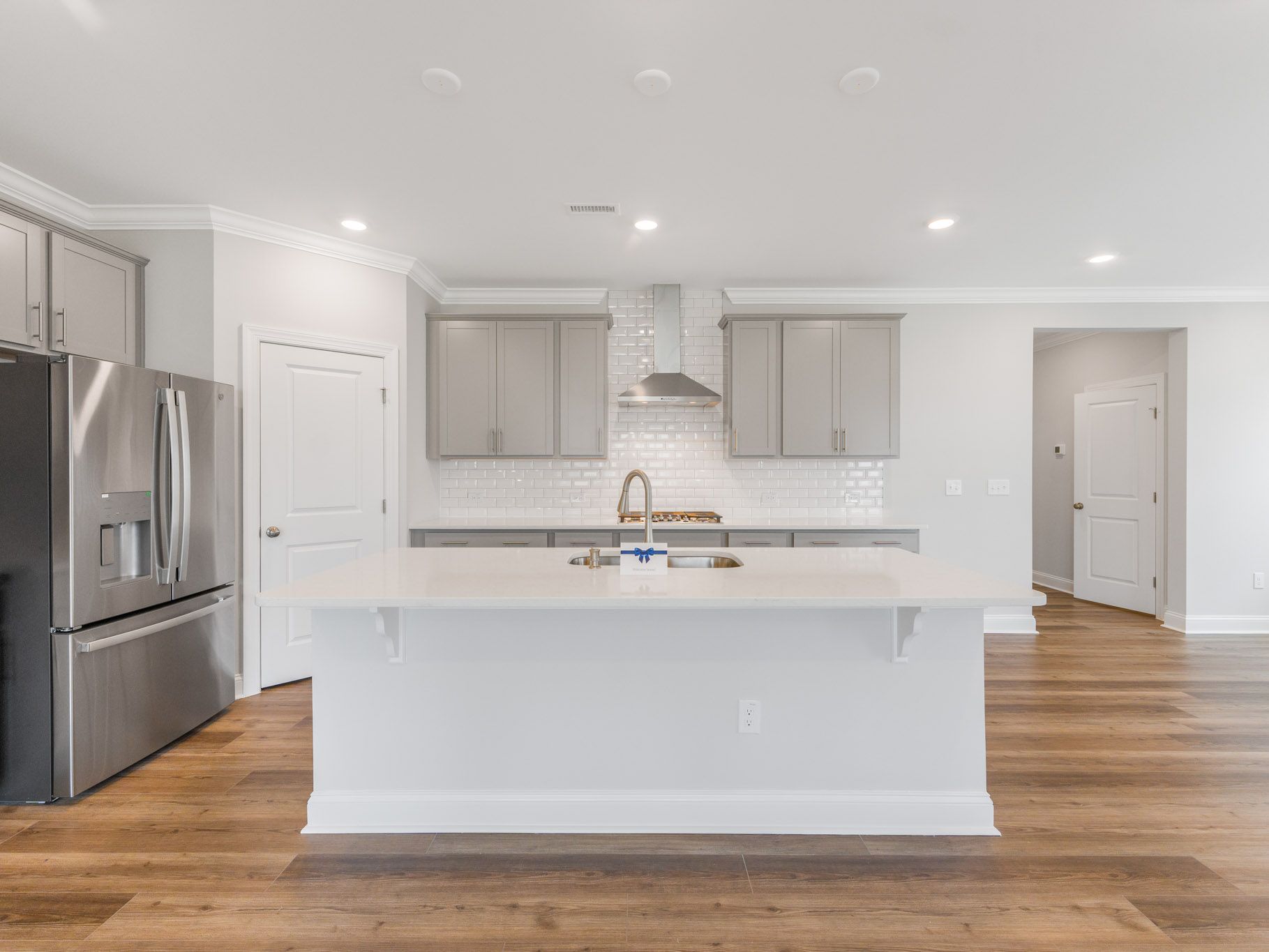 Open concept living space with white kitchen cabinets and hardwood floors.