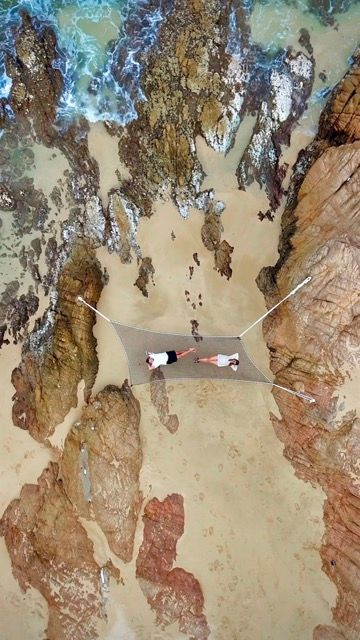 Aerial view of hammocks suspended over rocky canyon terrain.