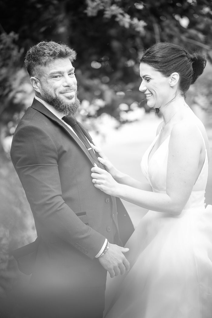 Black and white wedding photos show candid moments between bride and groom embracing outdoors.
