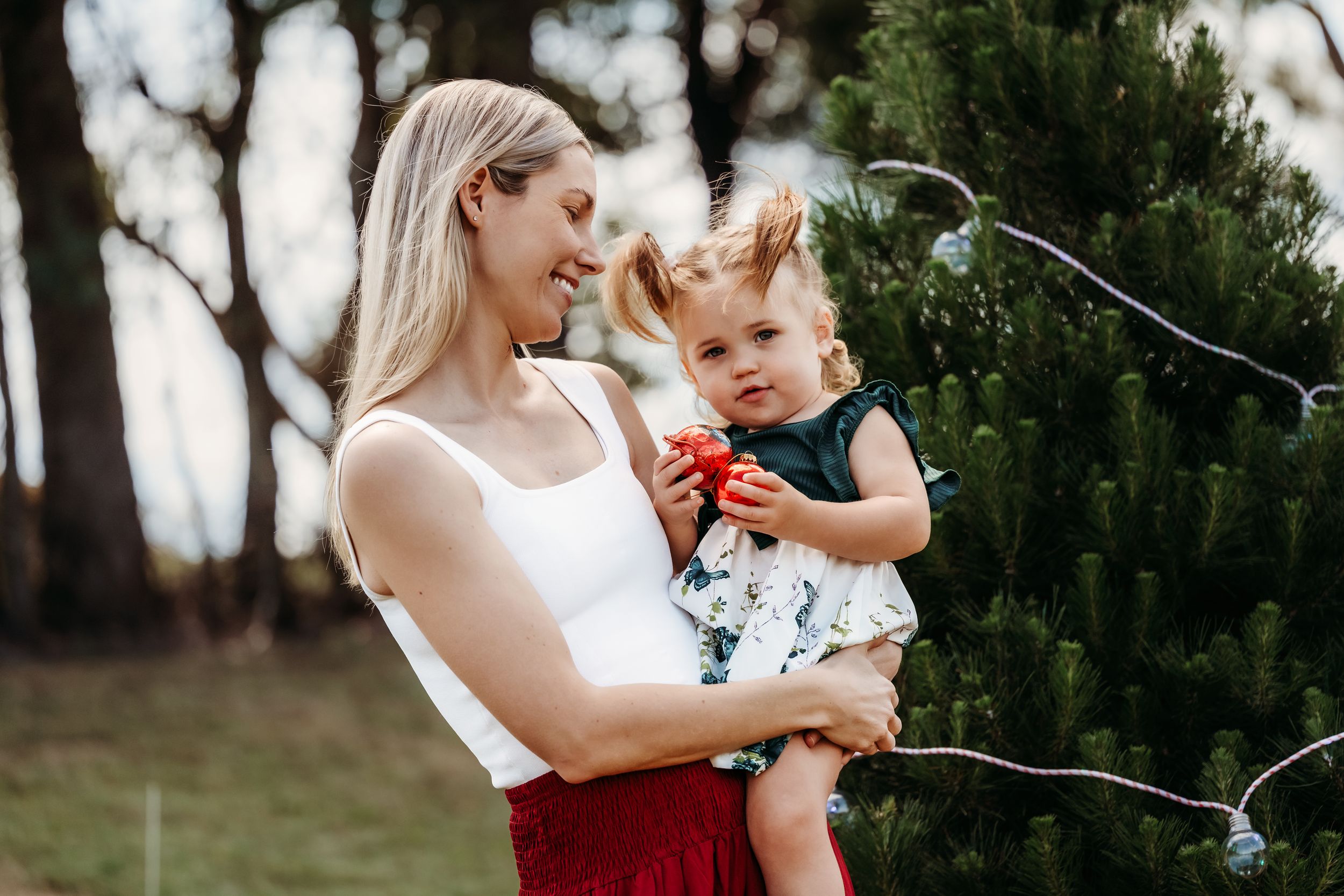 Mother and baby share joyful moments together in an outdoor natural setting during a lifestyle photo session.