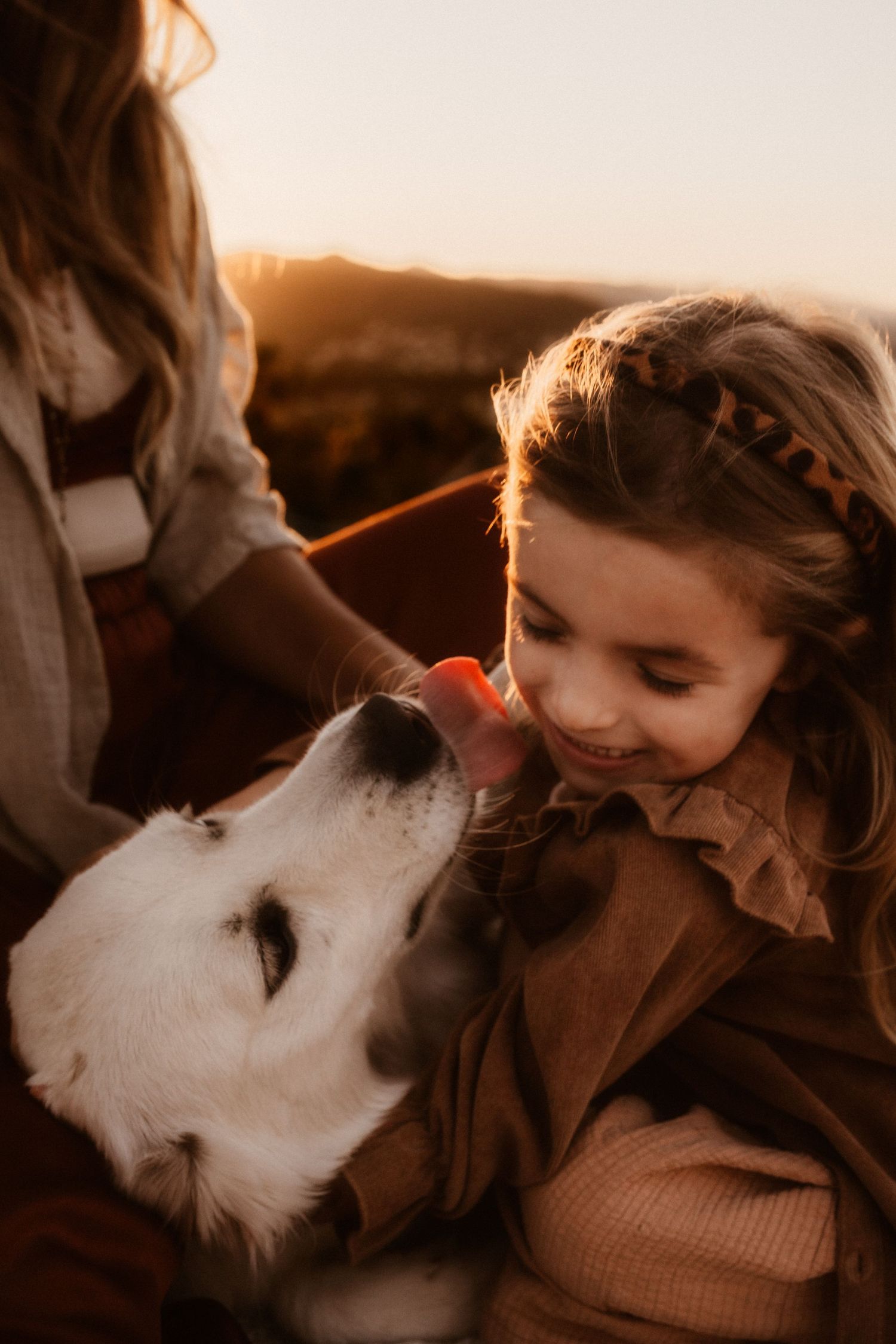 A white dog and child in Denia share a tender moment at golden hour -  Denia photographer