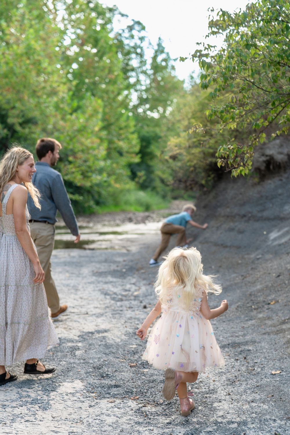 A series of candid moments showing people playing and walking on a rocky outdoor terrain surrounded by greenery in Cleveland for Family Pics