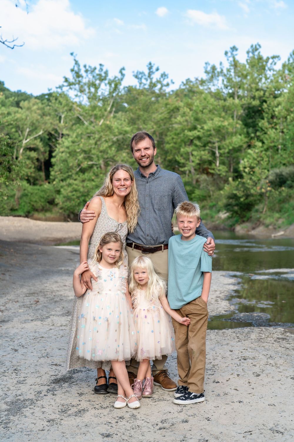 A group poses together on a rocky riverbank during an outdoor family photo session at Cleveland's Brecksville Reservation.