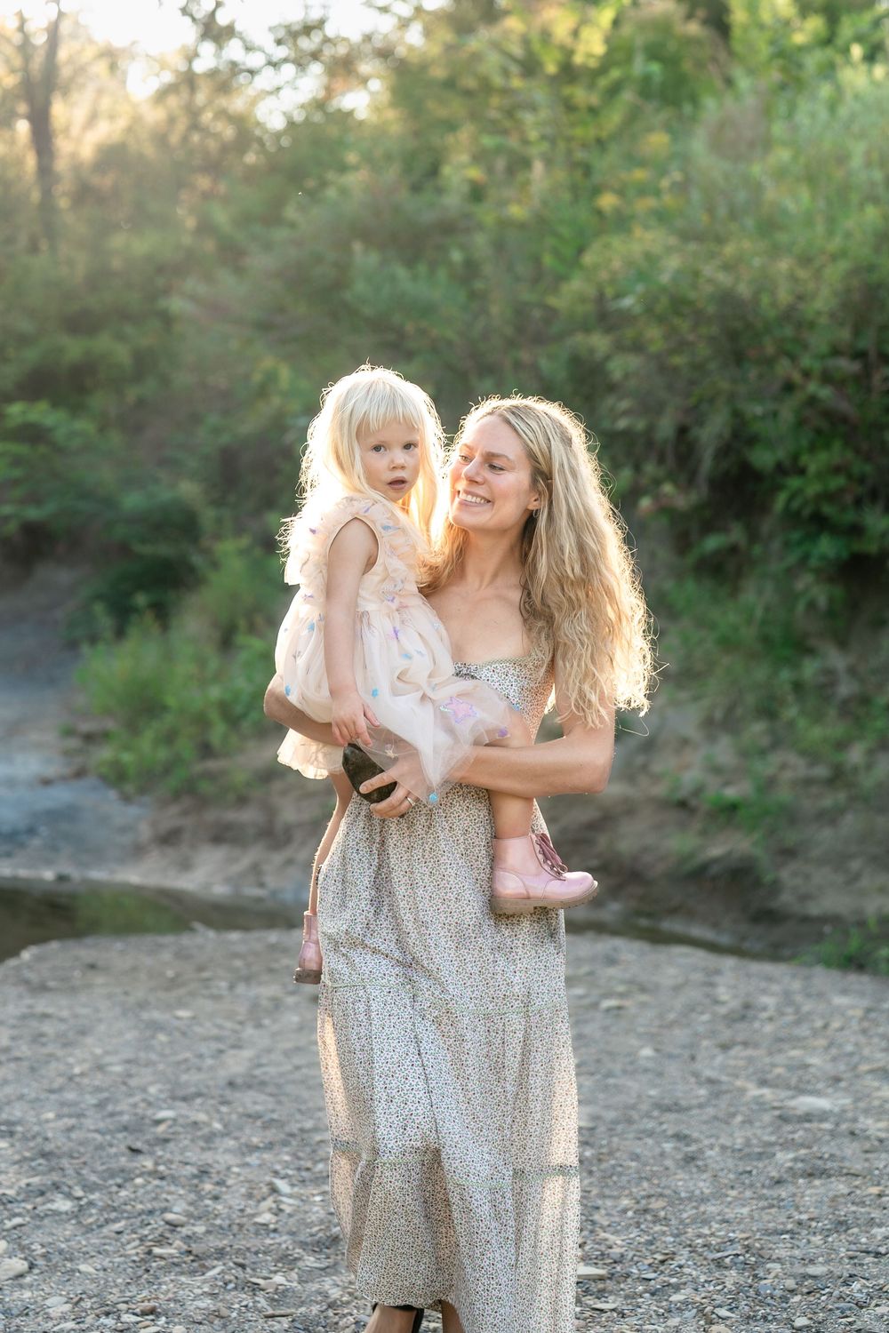A tender moment is captured between two in matching dresses by a rocky riverbank in Cleveland, Ohio's Brecksville Reservation Family Session