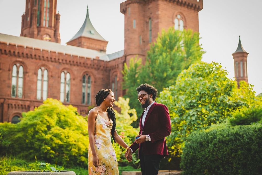 A couple walks along the grounds of the Smithsonian Castle in Washington DC on a sunny spring afternoon.