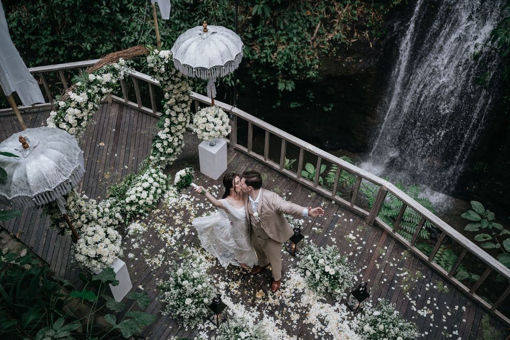 A romantic waterfall backdrop frames a wedding couple's special moment.