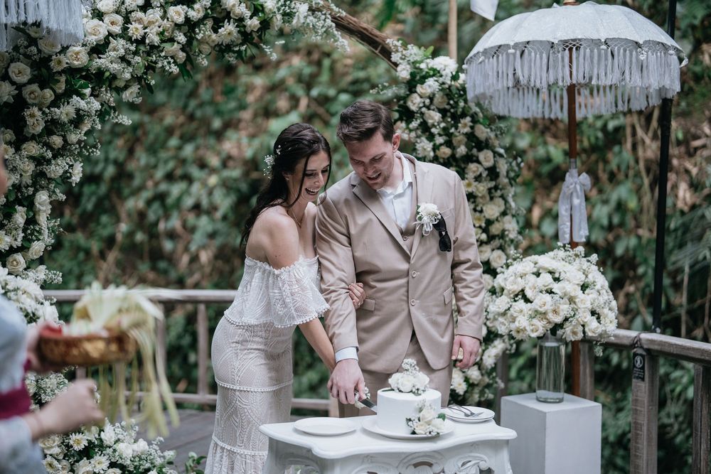 Wedding couple enjoys tea time together surrounded by white roses and elegant decor.