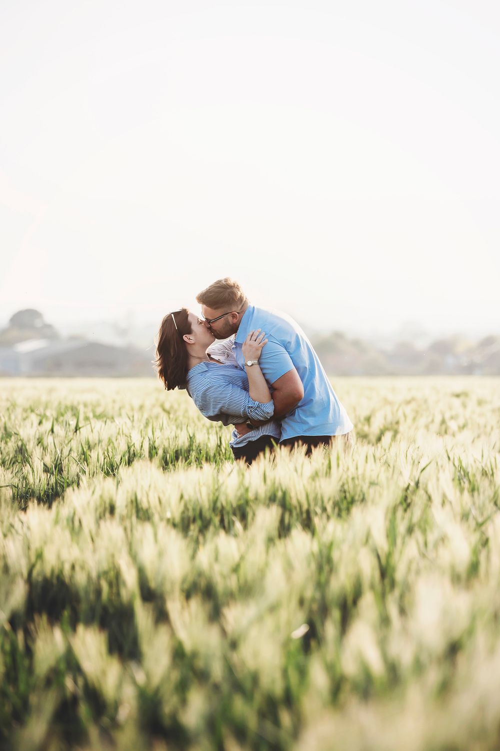 A romantic couple embracing in a golden wheat field during sunset, captured in a series of tender moments.