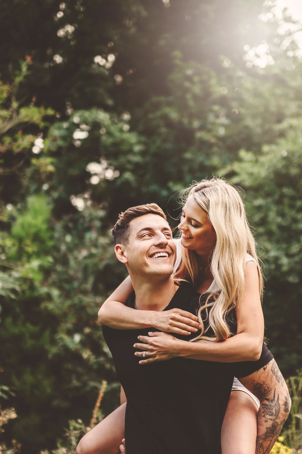 A couple shares intimate moments together while embracing outdoors in a natural setting.