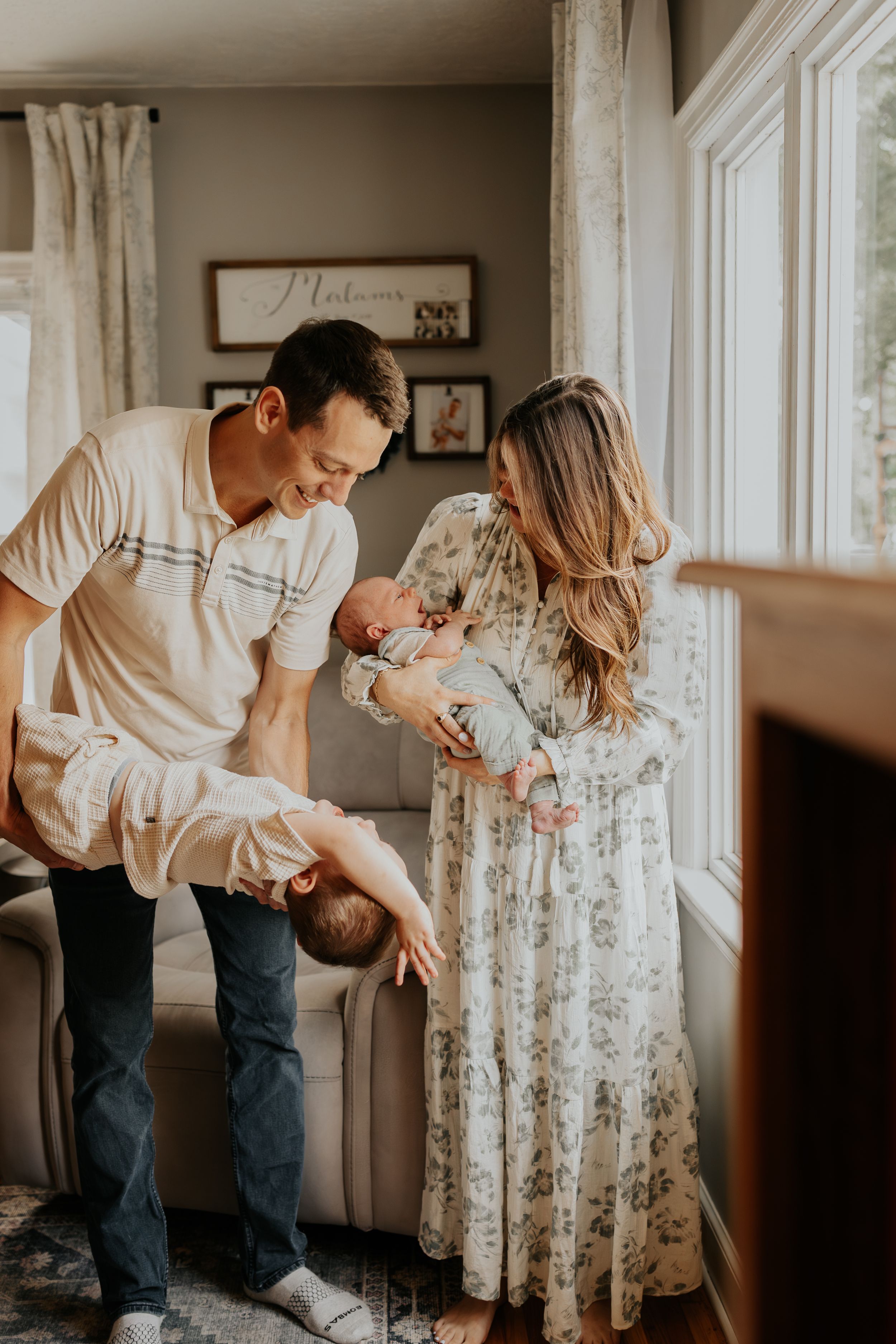 Candid lifestyle series shows tender moments of a couple embracing and dancing together in a bright sunlit room.