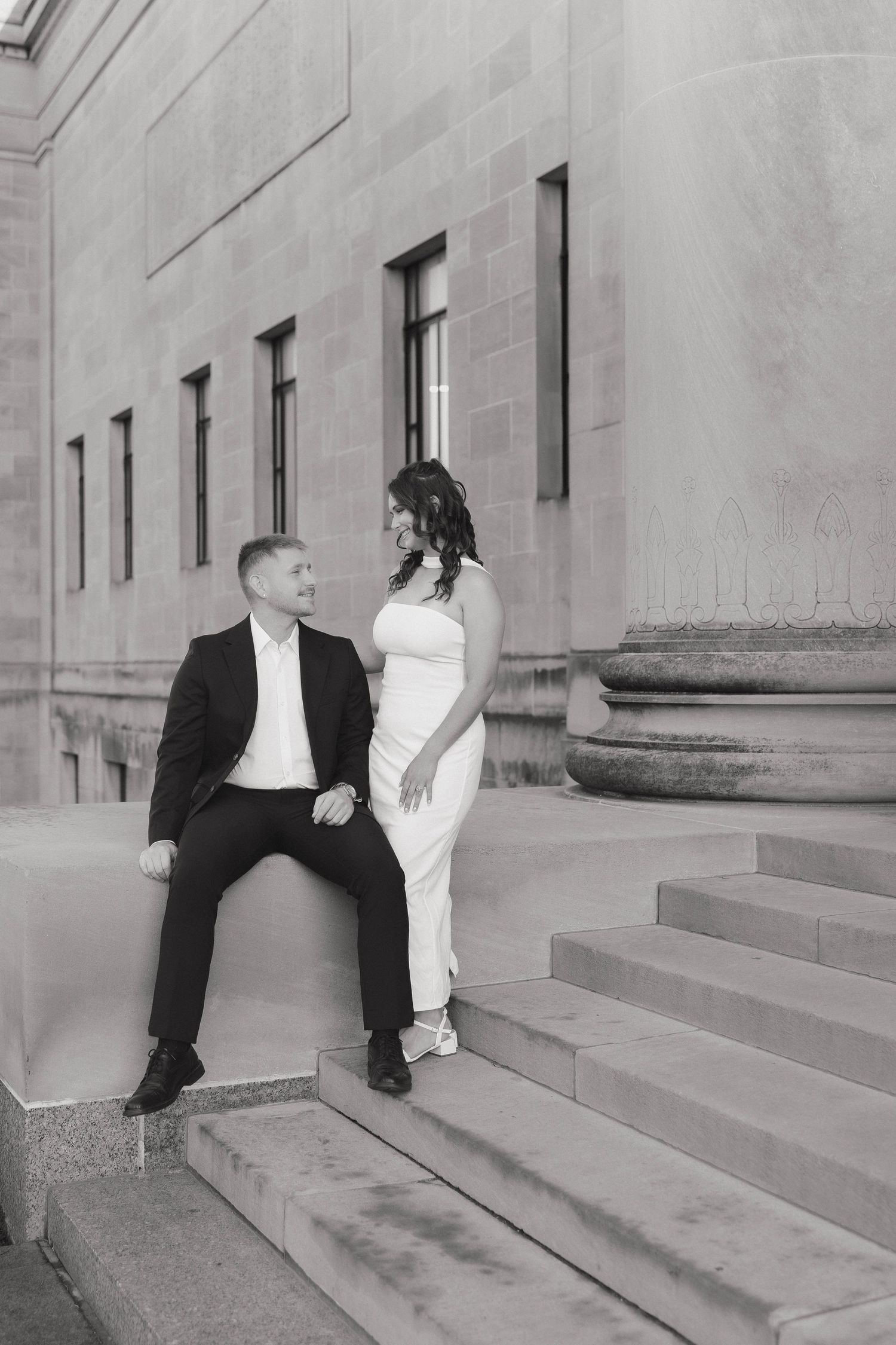 A sequence of black and white photos showing a couple on a building's stone steps creating romantic moments.