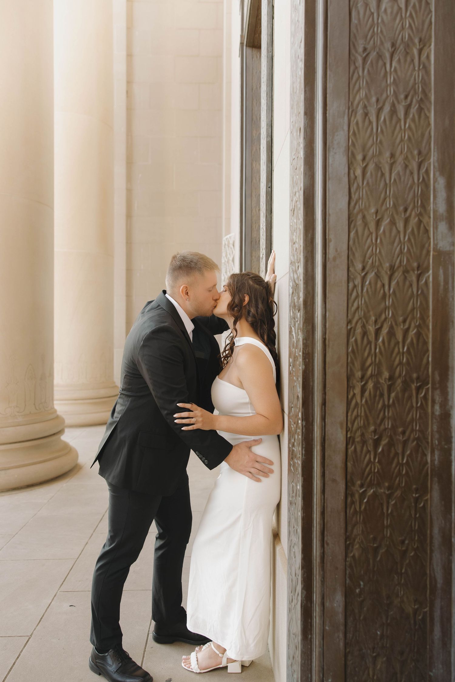 Sequence of four romantic moments between newlyweds by decorative wall panels.