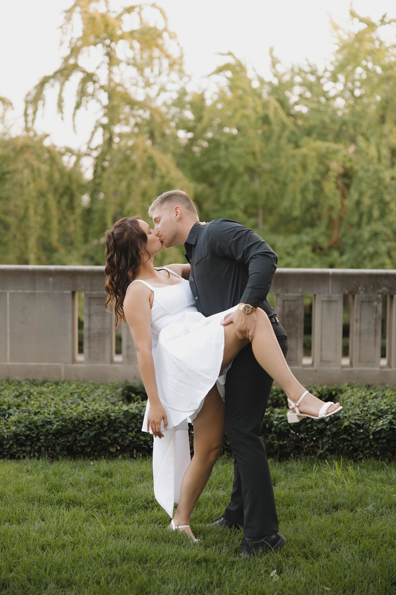 A romantic dance sequence captured outdoors with lush greenery providing a natural backdrop.