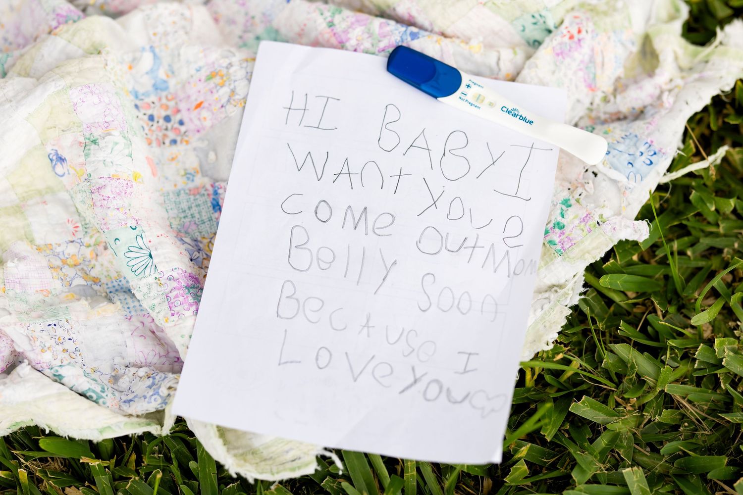 Written notes and messages of love and support rest among lush green foliage in a memorial display.