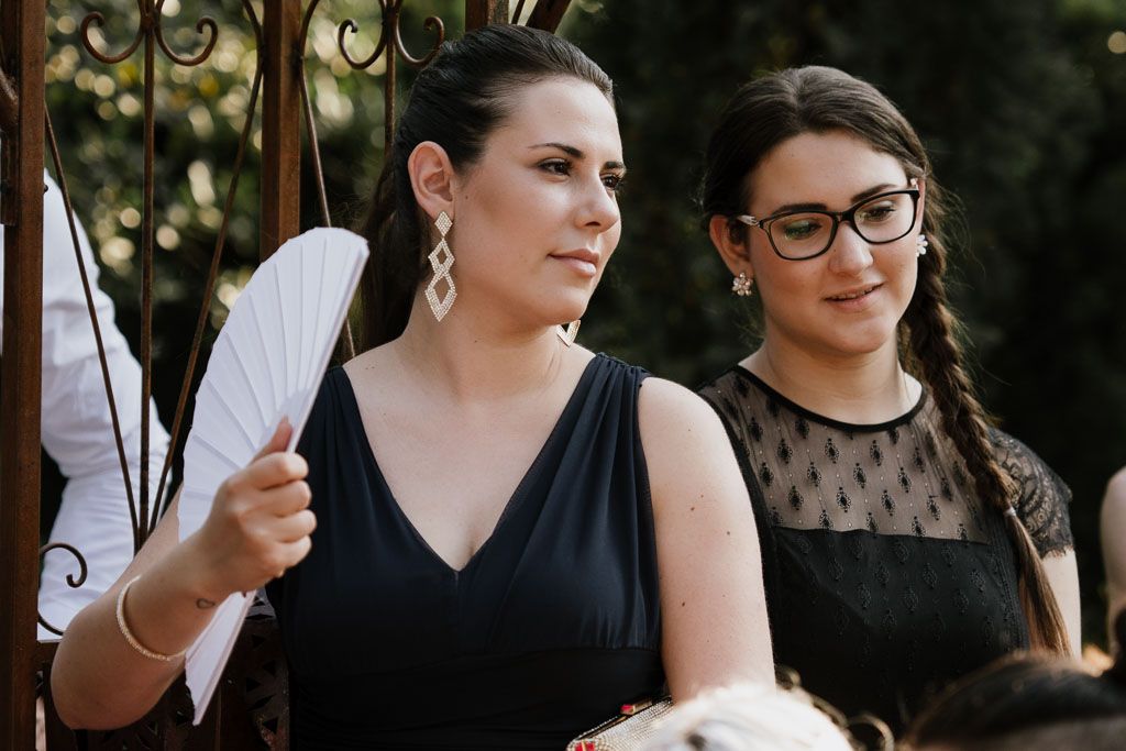 Wedding party members gather in a natural outdoor setting during festivities.