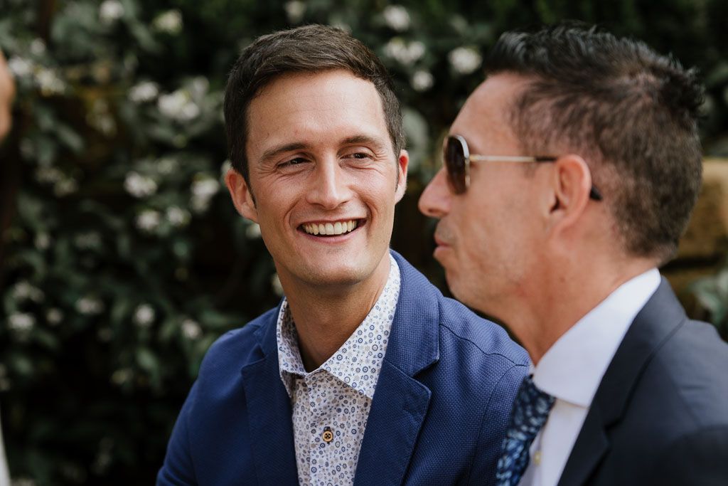 Two people in formal attire share a candid moment during an outdoor celebration.