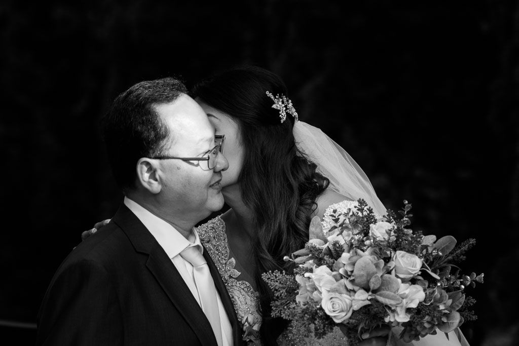 Couple shares intimate moment during wedding celebration with floral decorations.