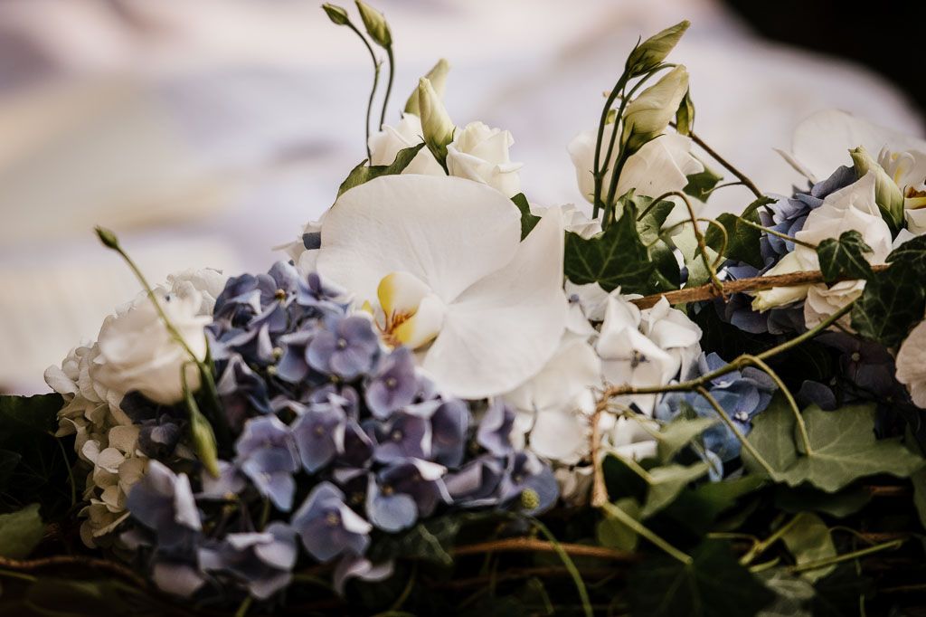 Close-up of delicate purple hydrangea and green foliage in a wedding floral arrangement.