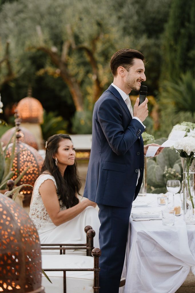 Wedding reception table setting with couple enjoying intimate moment outdoors.