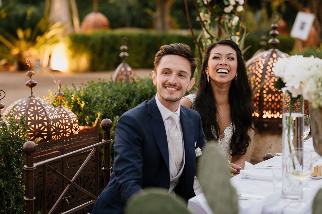 Wedding reception at sunset with twinkle lights and outdoor table settings.