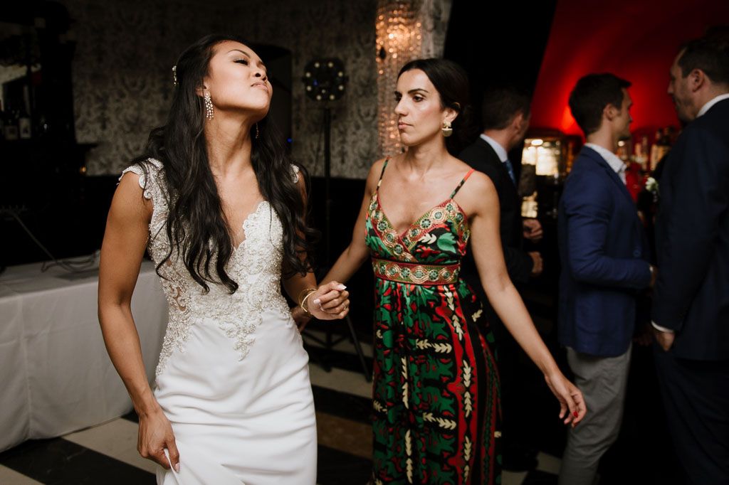 People dancing and celebrating at an elegant evening wedding reception with warm lighting and festive atmosphere.
